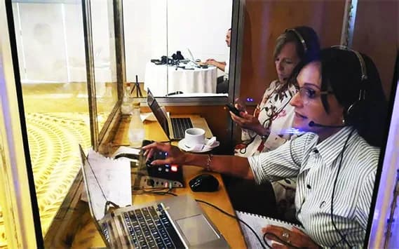Cabina de traducción simultánea con intérpretes